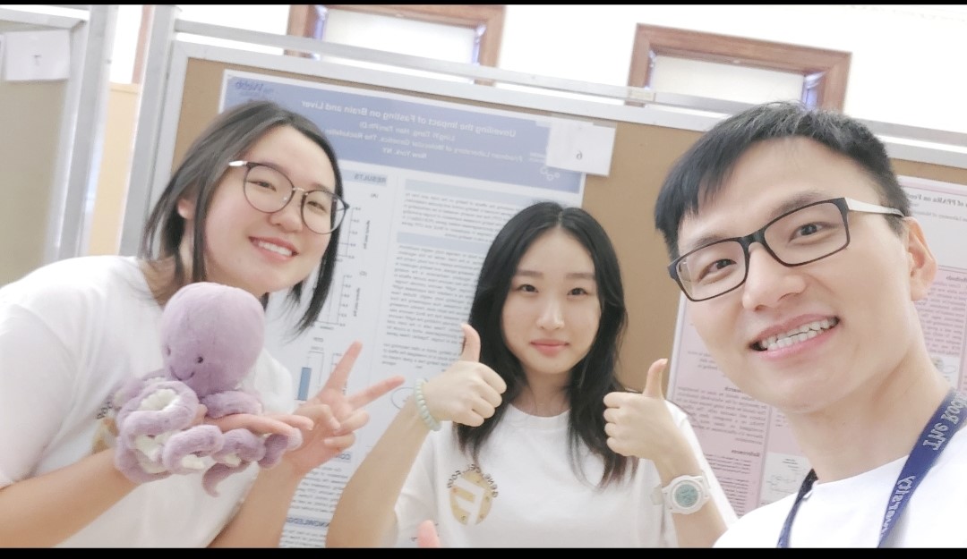 Group of three students in front of a research poster